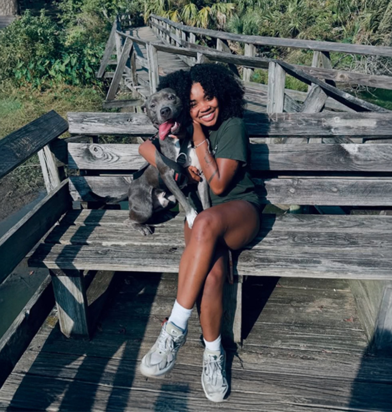 a woman posing with her dog outdoors
